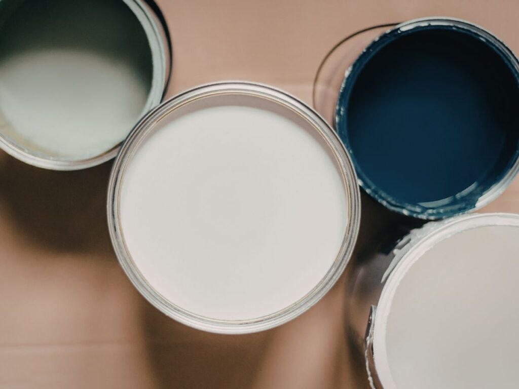Open paint cans showing white, cream, and dark blue color choices