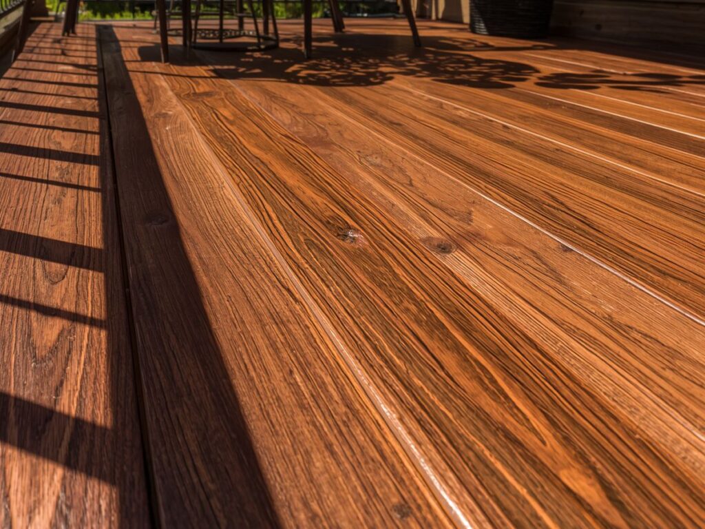 Sunlit close-up of a freshly stained wooden deck