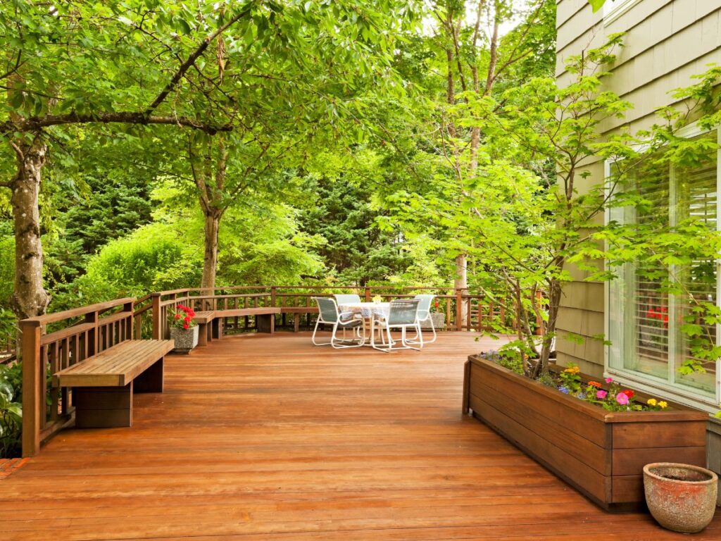 Spacious backyard deck surrounded by lush green trees
