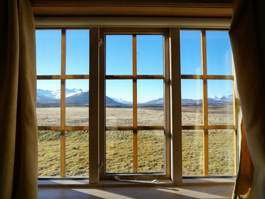 Mountain view through a wooden-framed window