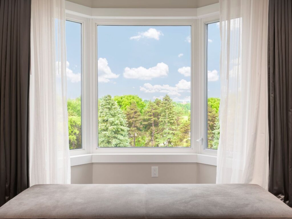 Large bay window overlooking trees and blue sky
